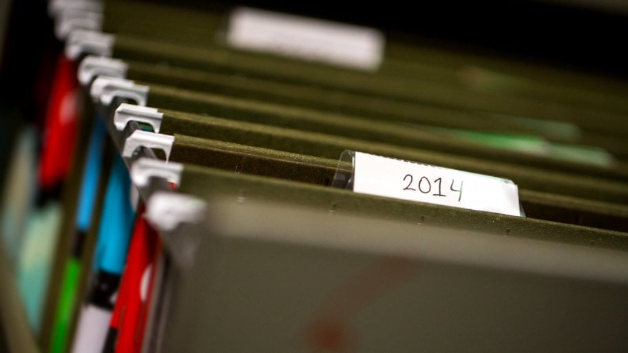 Paper file folders labeled by date.